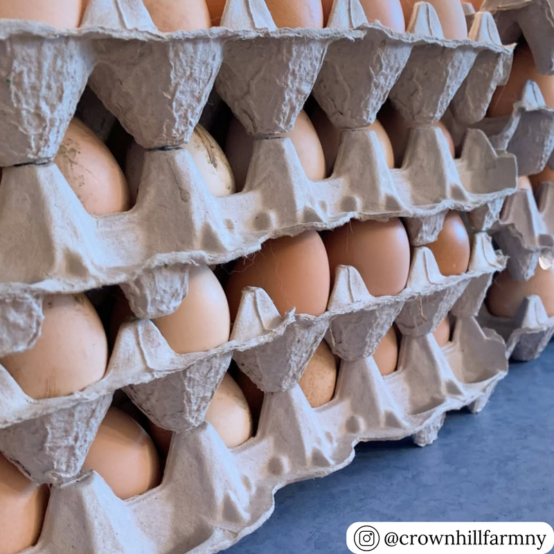  Gray 30-egg flat tray filled with brown eggs at a market stand.
