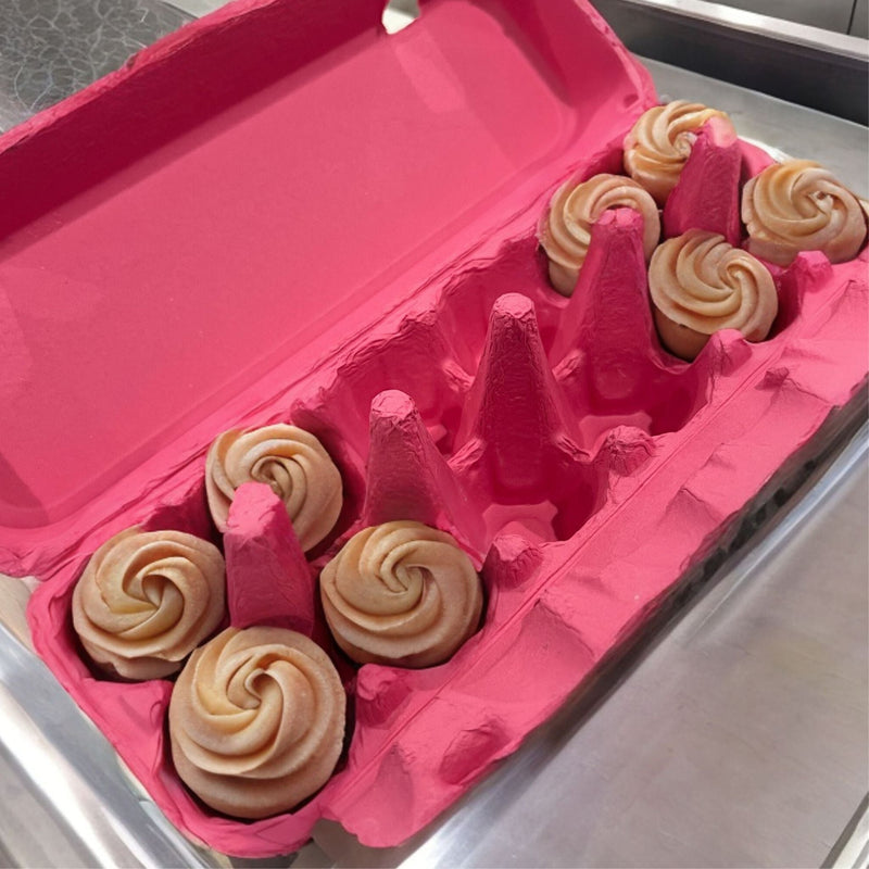 a pink paper pulp flat top carton with desserts inside