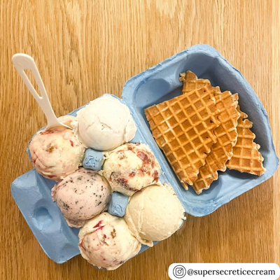 Blue unprinted pulp carton with ice cream scoops and waffles on a wooden surface