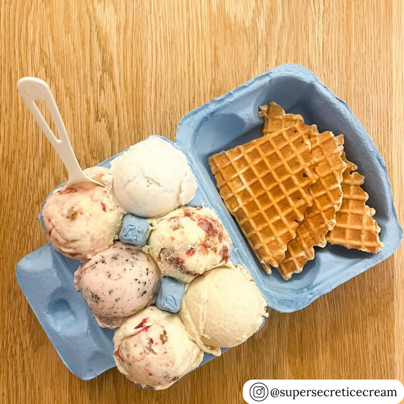 Blue unprinted pulp carton with ice cream scoops and waffles on a wooden surface